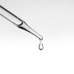 Close,Up,Pipette,With,Drop,On,White,Background.