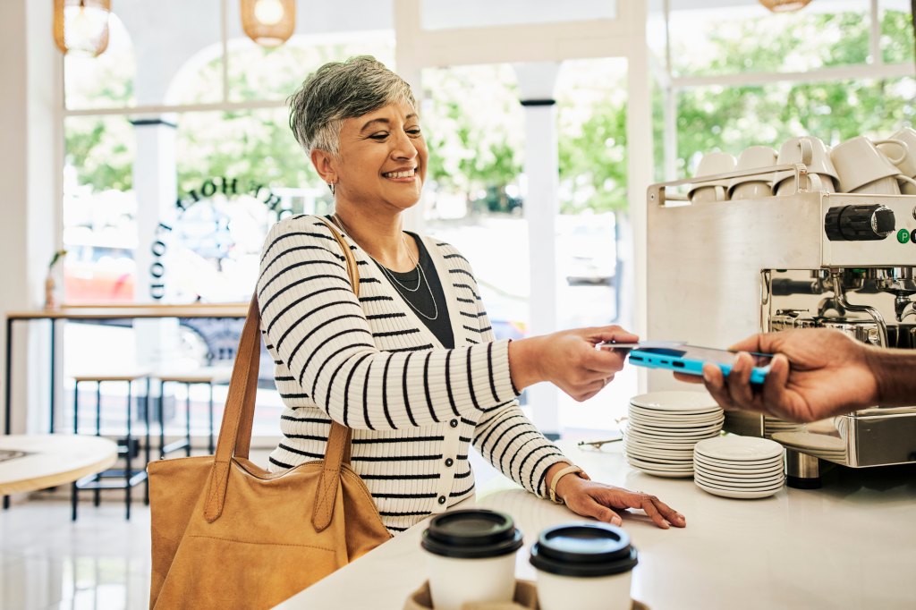 mature woman paying for a drink at Starbucks after the open-door policy reversal