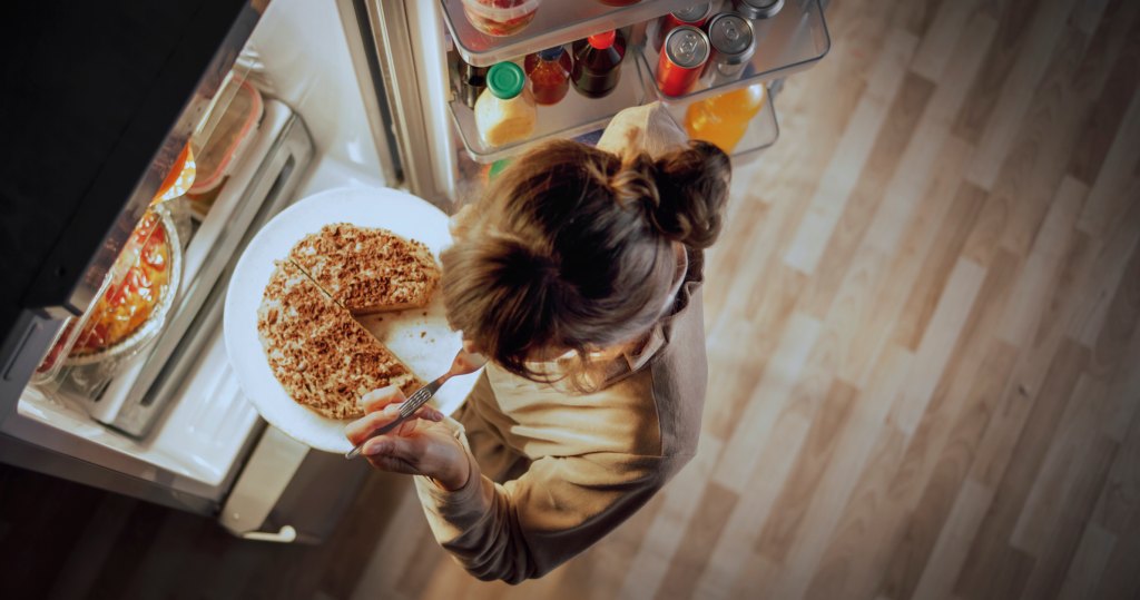 woman storing leftover pizza in the fridge before reheating in the air fryer