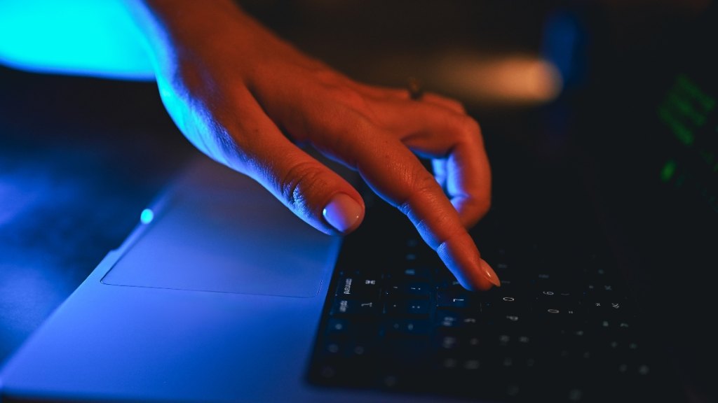 A mysterious hand typing on a computer